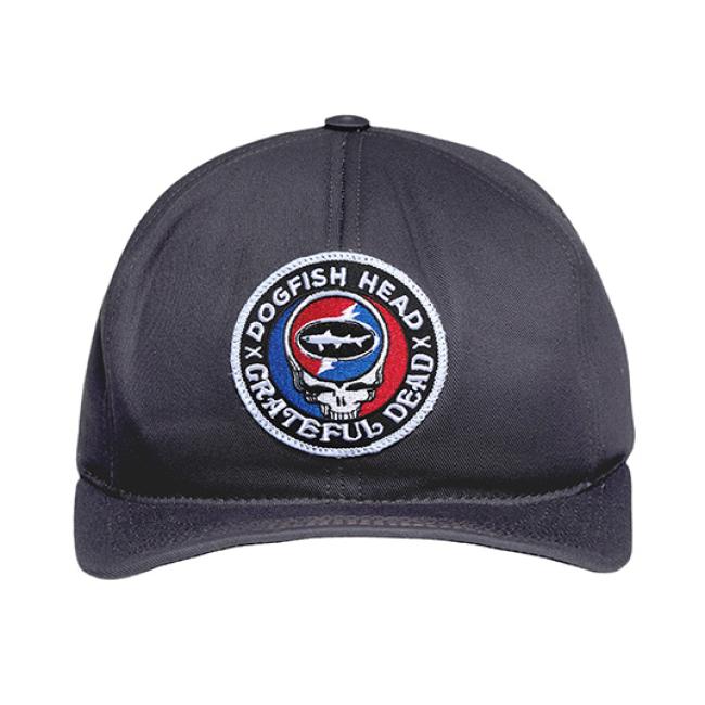 The Dogfish Head x Grateful Dead Charcoal Flat Brim by GRAFFITI INC is a black snapback hat with a vintage look, featuring an embroidered patch with the Dogfish Head shark logo on a red, white, and blue background.
