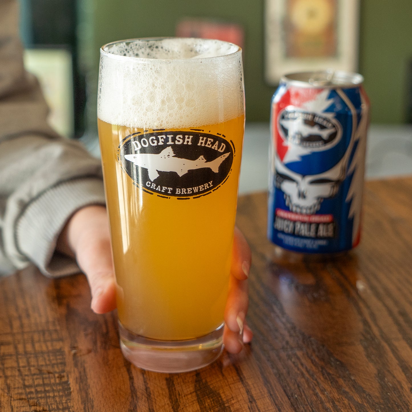 Dogfish Head craft brewery beer glass with a can on a wooden table