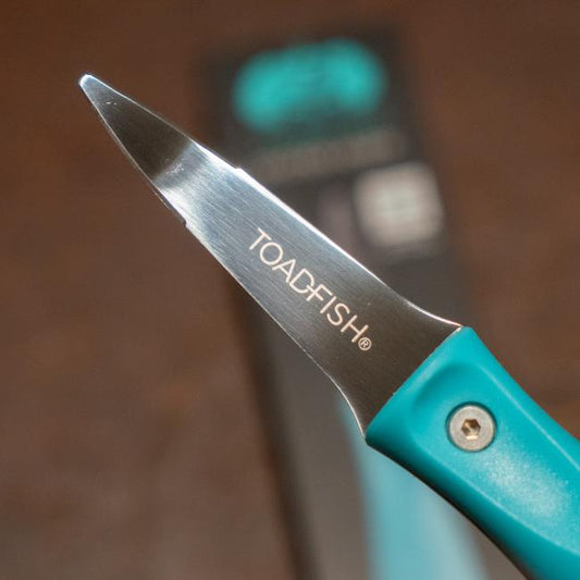 Blue oyster knife features the Dogfish Head shark and shield logo engraved on one side of the knife. The other side of the knife features the Toadfish logo engraved.