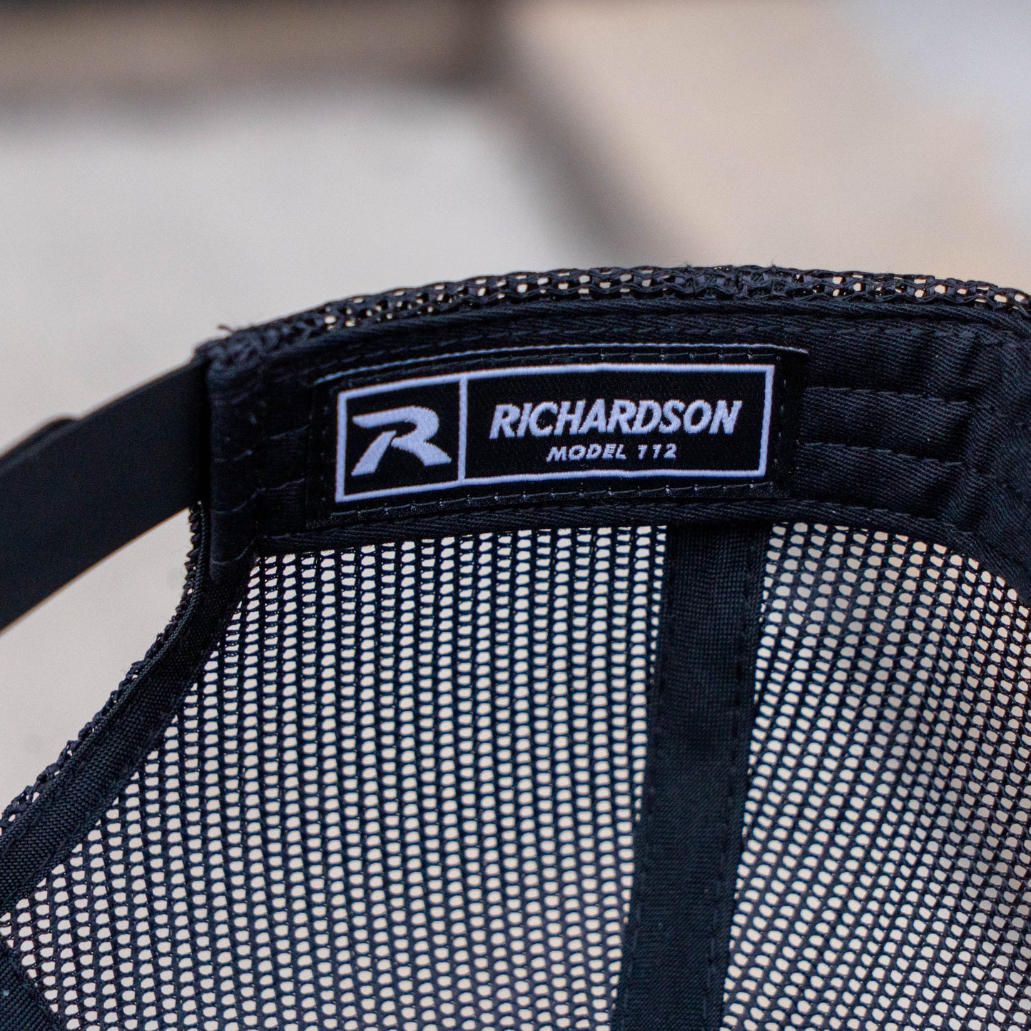 Close up of the inner logo of the trucker hat. Inner tag reads "Richardson Model 112"
