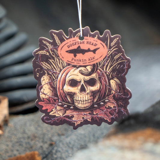 A die-cut hanging air freshener or tag featuring a skull, corn, and autumn leaves design with the text 'DOGFISH HEAD Punkin Ale'.