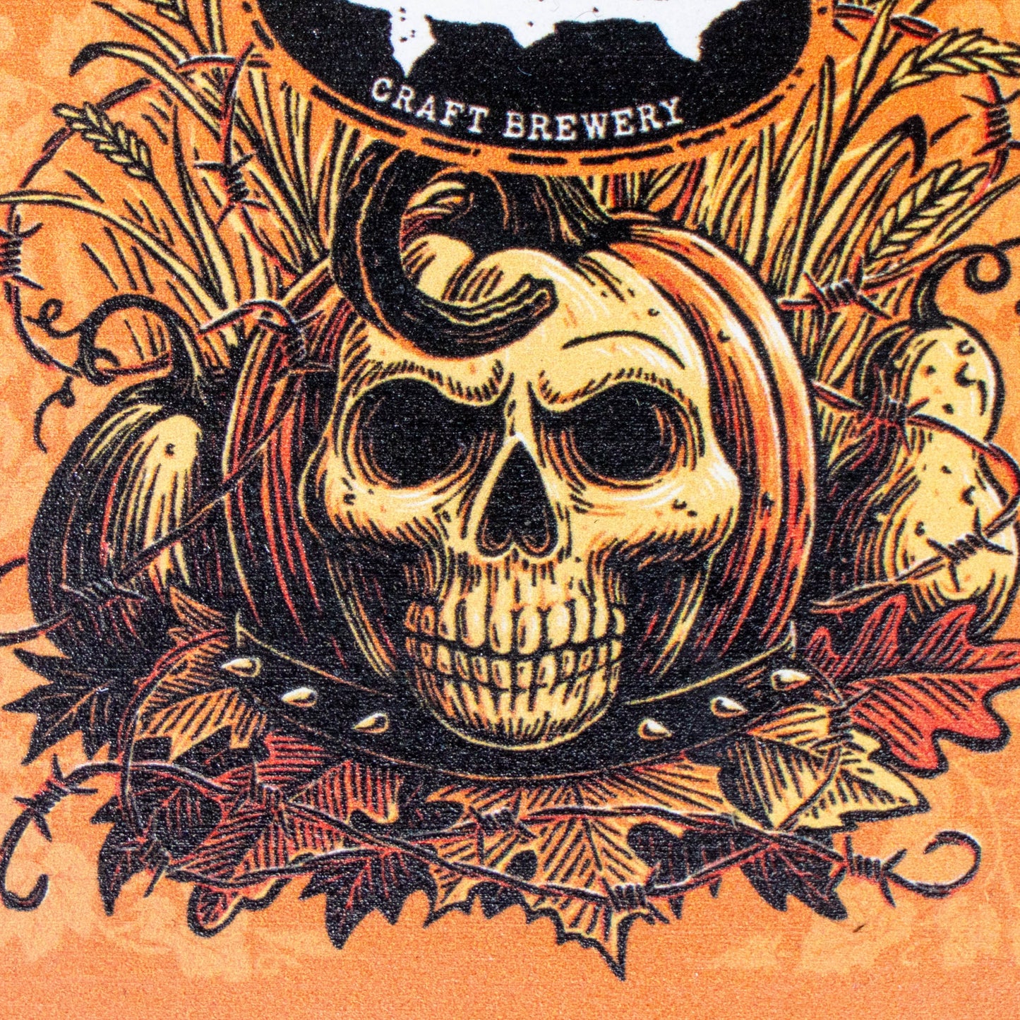 A Halloween-themed graphic illustration featuring a central skull wearing a pumpkin hat, surrounded by pumpkins, autumn leaves, and barbed wire on an orange background. A black oval at the top reads 'CRAFT BREWERY'.