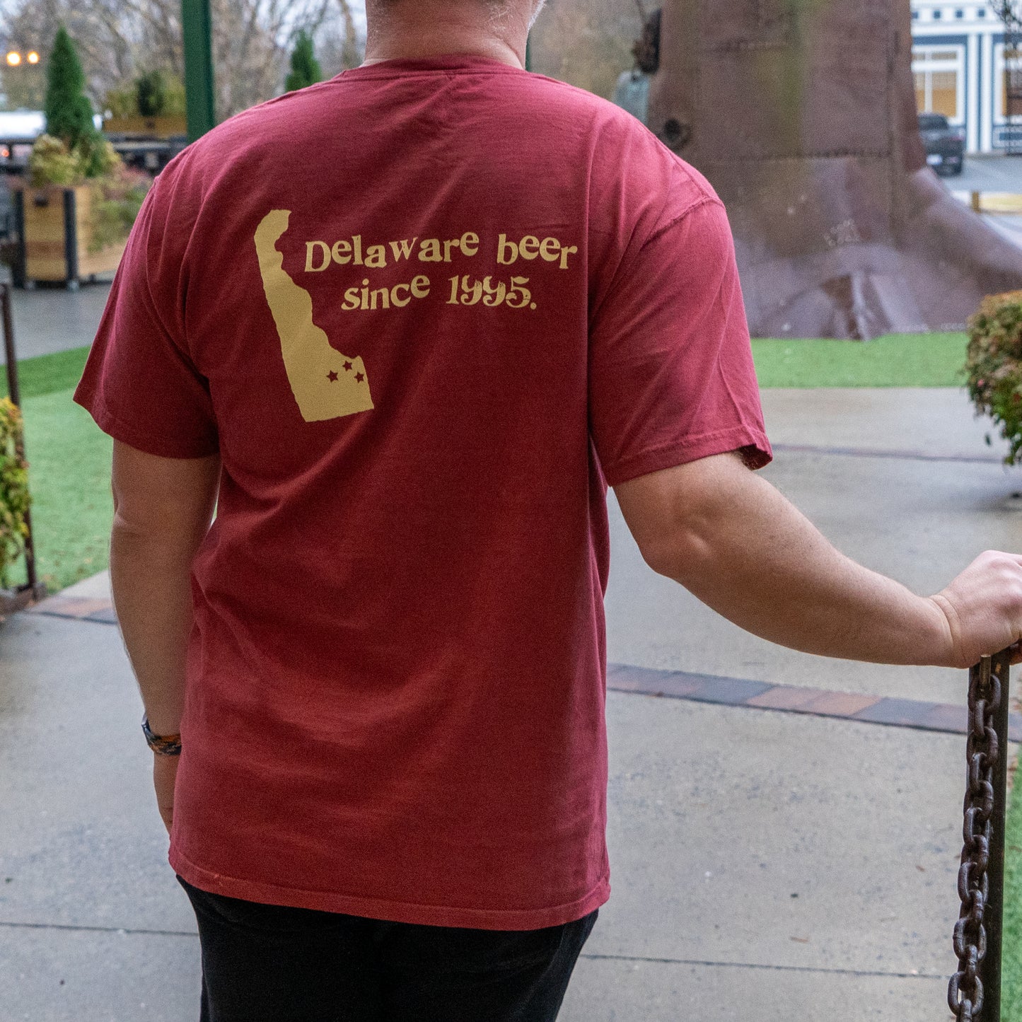Person wearing a red t-shirt with 'Delaware beer since 1945' text on the back.