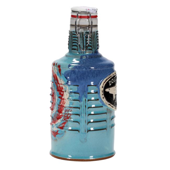 The Tie Dye Ceramic Growler by Romanick Pottery is a handcrafted ceramic bottle with a flip-top lid, blue glaze with red accents, ribbed details, and a partially visible black and white "DOG" label on the side.
