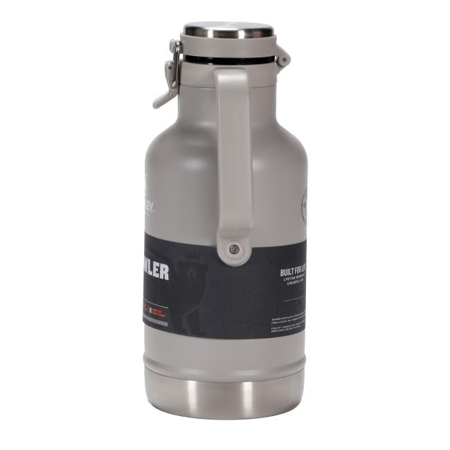 A light gray insulated growler with a stainless steel base and top. It has a sturdy gray handle attached to the side, extending from near the top to about midway down the body. Two black labels are visible on the growler's body.