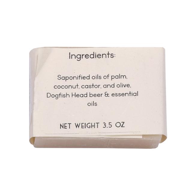 A white label on Parsonage Handmade Soaps’ Beer Shampoo lists saponified oils of palm, coconut, castor, olive, Dogfish Head beer, and essential oils. Net wt: 3.5 oz. The label is slightly curled at the edges.