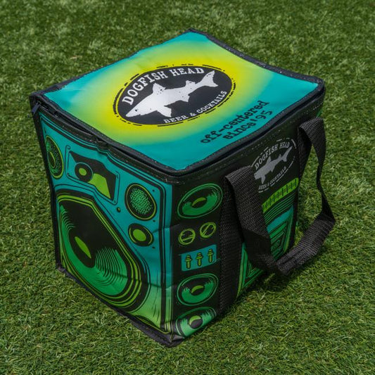 A colorful Go Match Up Cooler Bag with beer graphics sits on green grass; its retro stereo design features boombox speakers and a cassette player, making it both fun and functional.