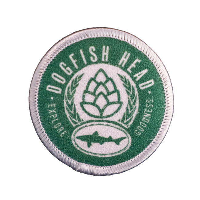The DFH Explore Goodness Patch by GRAFFITI INC. features green and white embroidery with "Dogfish Head," a hop cone, wheat, shark silhouette, and the words "Explore" and "Sustain" to inspire goodness with every sip.