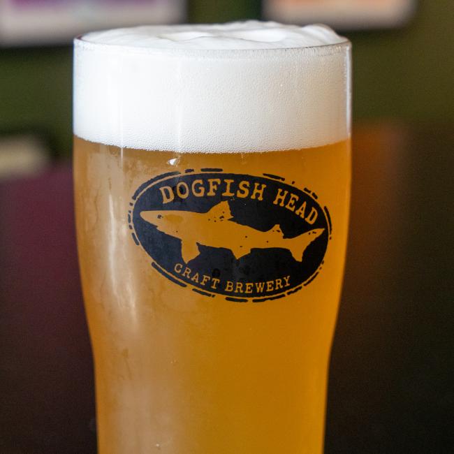 Raise a Dogfish Head Brewhouse Glass by Sahm Glass Inc, filled with golden beer and a foamy head—perfect for showing your Delaware pride.