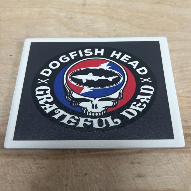 The Dogfish Head x Grateful Dead Ceramic Coaster by Paint the Town, Inc. features both logos with a skull and red, white, and blue lightning bolt—ideal for fans or as a unique collectible.