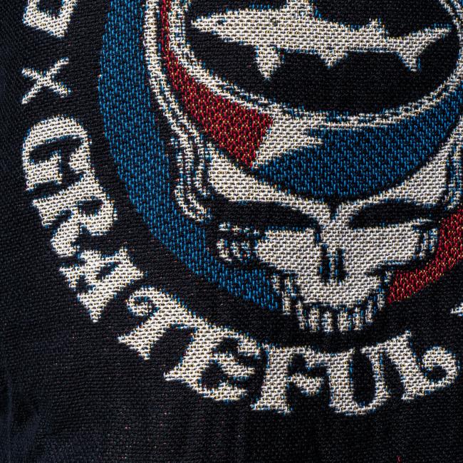 A close-up of an embroidered patch on the Dogfish Head x Grateful Dead Fiber Art Hoodie by Pure Country Inc - Fiber Art, featuring a skull with a lightning bolt in red, white, and blue, and "GRATEFUL" in stylized text.