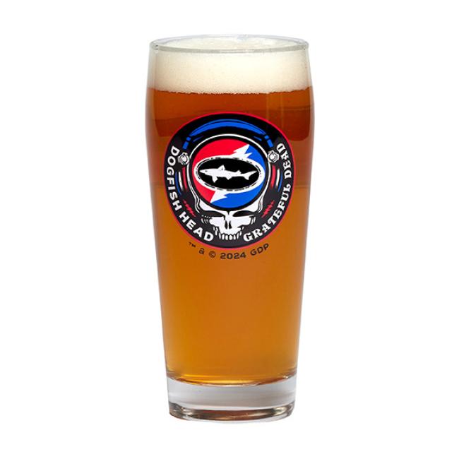 The Dogfish Head x Grateful Dead Glass by Grandstand Glassware & Apparel is a pint glass with amber beer, showcasing a 2024 shark silhouette and colorful skull logo collaboration design.