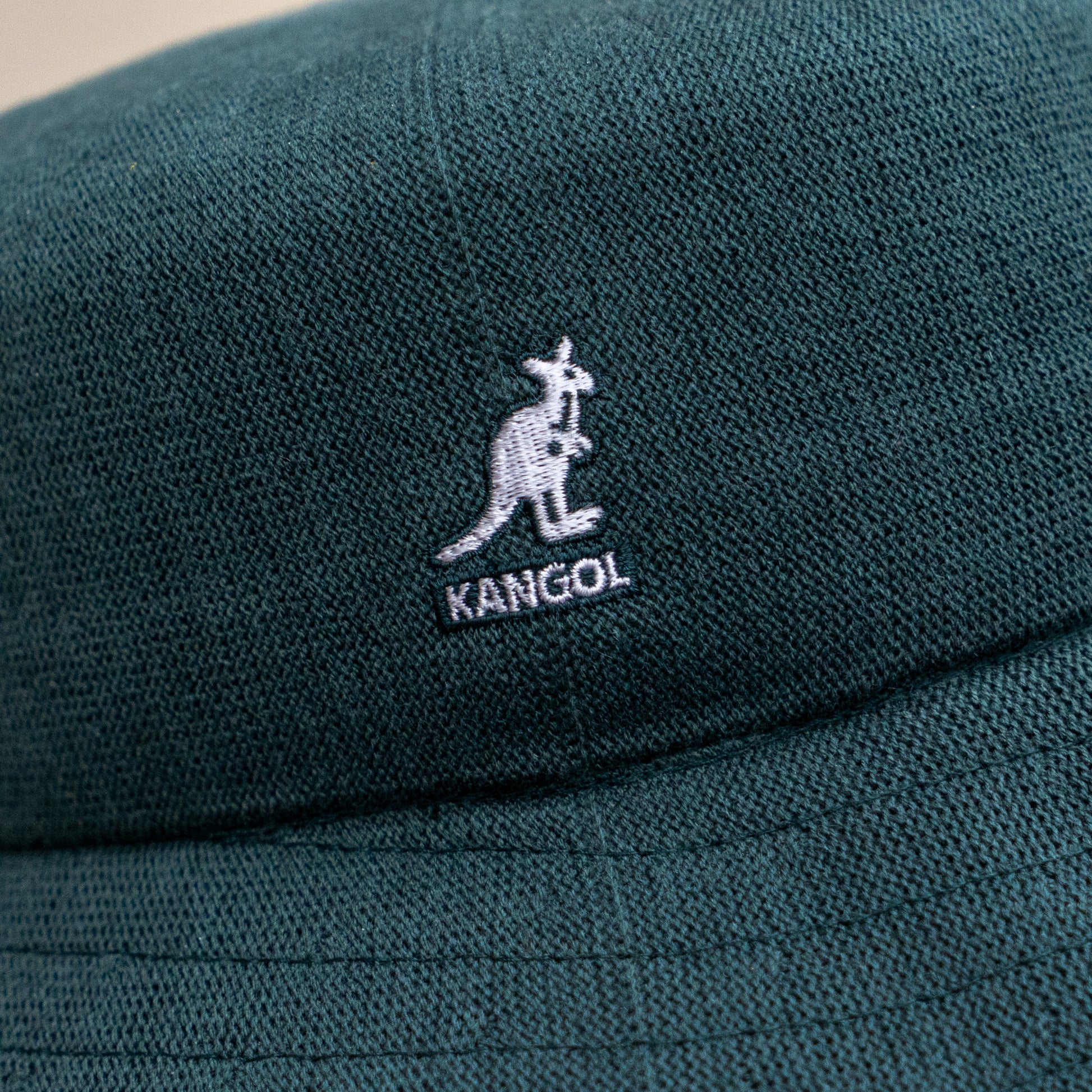 Close-up of the Dogfish Head x Grateful Dead KANGOL Bucket Hat by BOLLMAN HATS, green with a white kangaroo logo and KANGOL text embroidered on the fabric.