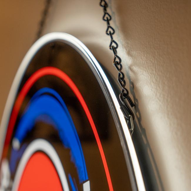 A close-up of the Firebolt Group Dogfish Head x Grateful Dead LED Sign, featuring blue, red, and white colors. Hanging from a black metal chain, this stylish bar decor highlights the sign’s edge and partial design.
