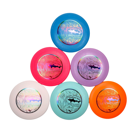 Six Innova Disc Golf Driver Discs in blue, pink, purple, white, mint green, and orange are arranged hexagonally on a white background. Each disc features a shiny patterned label with the Dogfish logo at the center.