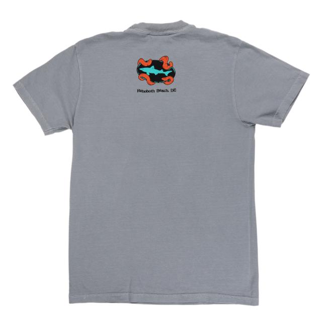 The Granite Kraken Short Sleeve Tee by GO WEST T-SHIRT COMPANY is a gray tee with a colorful abstract wave design and "Rehoboth Beach, DE" printed on the upper back.