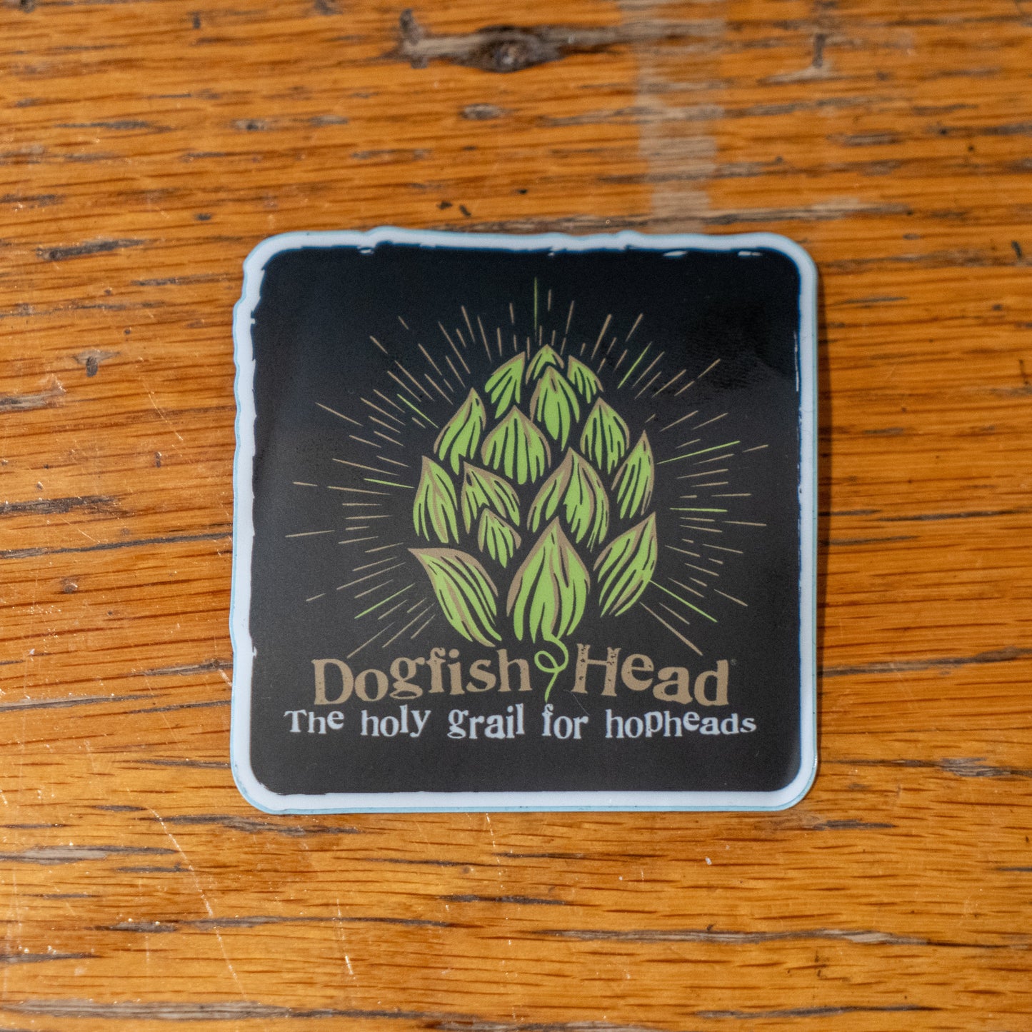 Black sticker with green hophead logo on it. With writing "Dogfish Head" and "The holy grail for hopheads" underneath.