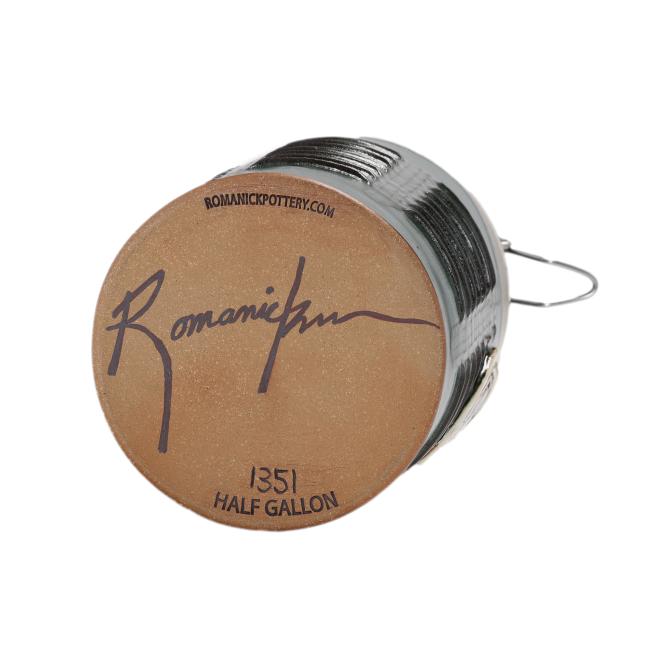 The unglazed base of the Hunter Green Ceramic Growler by Romanick Pottery displays a website, signature, “1351,” and “Half Gallon.” This handcrafted growler also includes a convenient wire handle for easy carrying.
