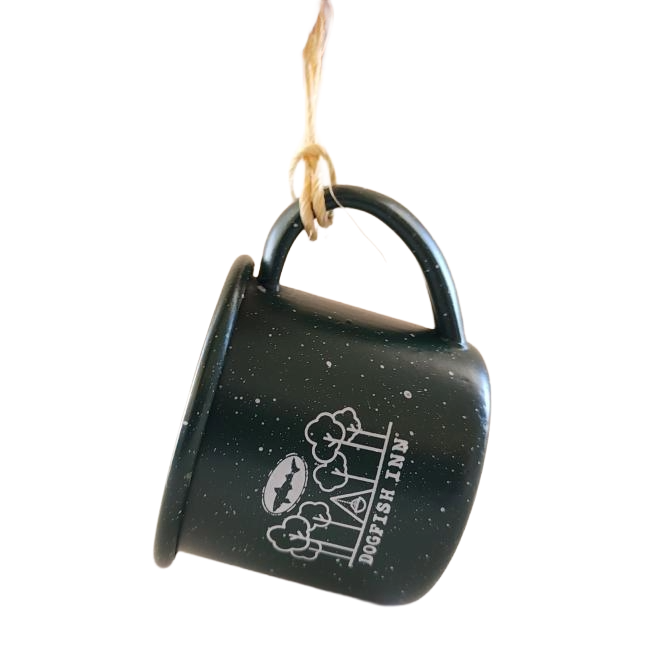 Green mug ornament with a brown string on the handle to hang. Mug features white imagery of trees and a Dogfish Head shark and shield logo, below all is writing "Dogfish Inn".