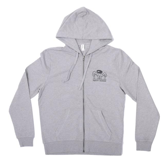 The INN Heather Grey Compass Zip Hoodie by GO WEST T-SHIRT COMPANY is made from organic French Terry cotton, with a front pocket, hood, and a small black chest graphic. Shown laid flat on a white background.
