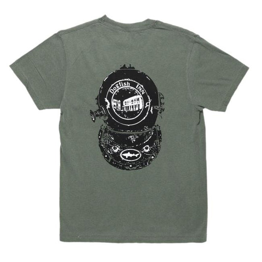 Moss green tee features a black diver helmet on the back with writing "Dogfish Head INN" on it and the Dogfish Head shark and shield logo on the bottom of it. The center where one would look through features imagery of a building.