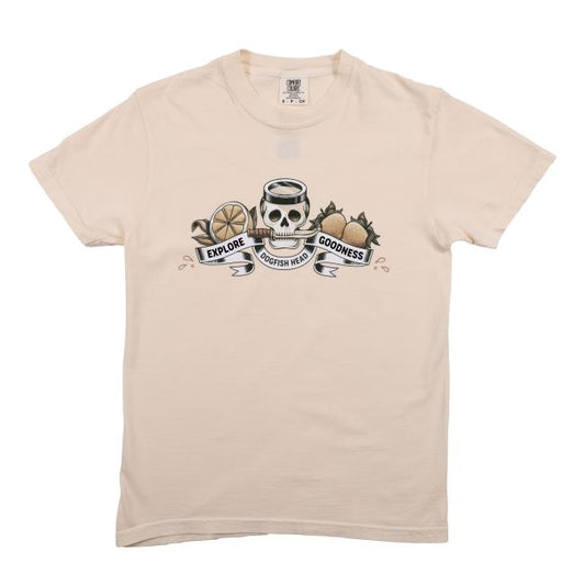 The Ivory Explore Goodness Skull Short Sleeve Tee by GO WEST T-SHIRT COMPANY is a unisex cotton t-shirt featuring a bold skull with a halo, lemon slices, hops, and "Explore Goodness" banner below the graphic.