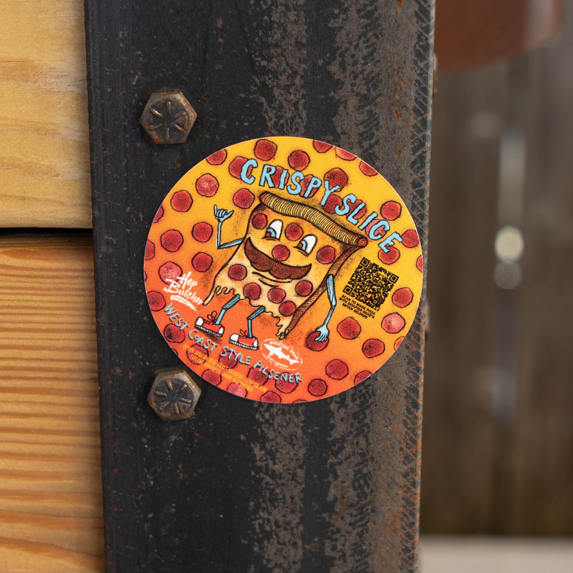 A round sticker from GO WEST T-SHIRT COMPANY’s Crispy Slice Merch Bundle shows a cartoon pizza slice labeled CRISPYSLICE and German Style Pilsener—fun pepperoni-themed art perfect for a tee or pint glass.