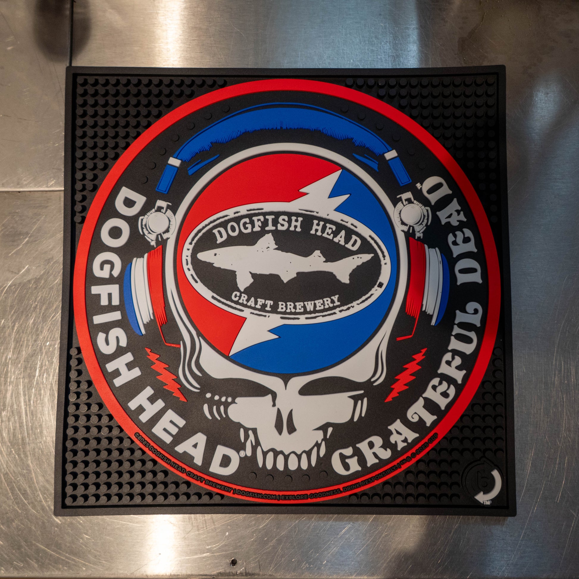 Black square bar mat with a red, white, and blue Dogfish Head x Grateful Dead Logo, designed in the classic Grateful dead skull.