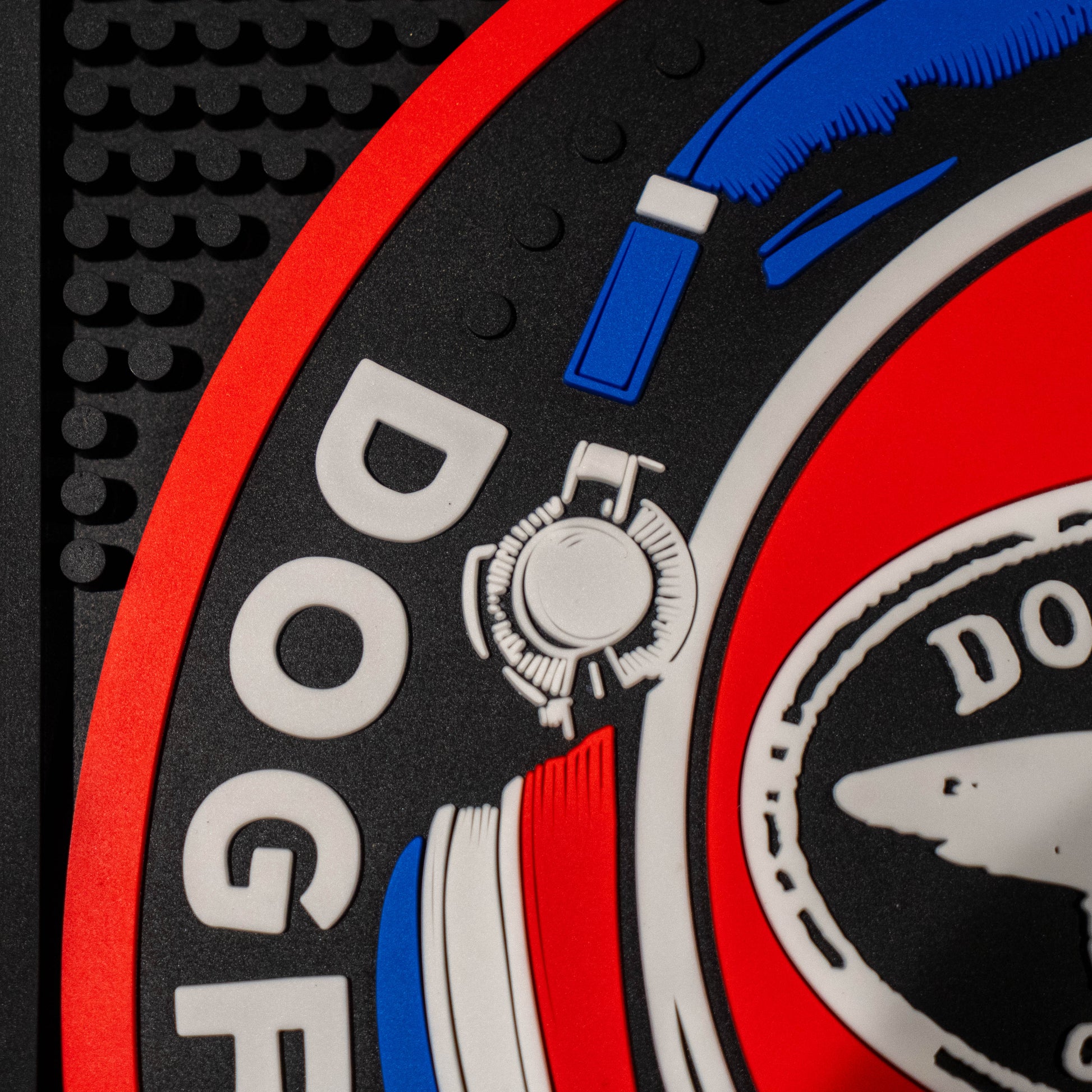 Close up of black square bar mat with a red, white, and blue Dogfish Head x Grateful Dead Logo.