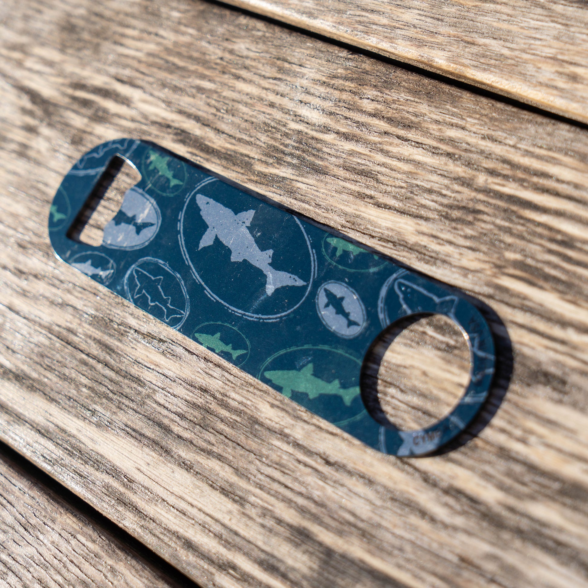 Bottle opener with shark design on a wooden surface