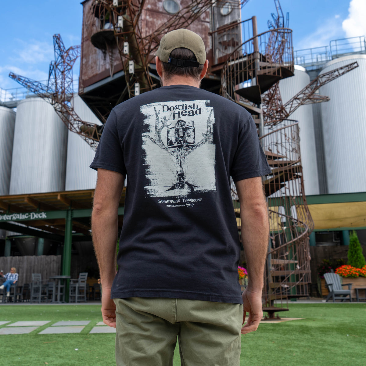 Male standing facing away, wearing black short sleeve tee shirt that reads 'dogfish head'.