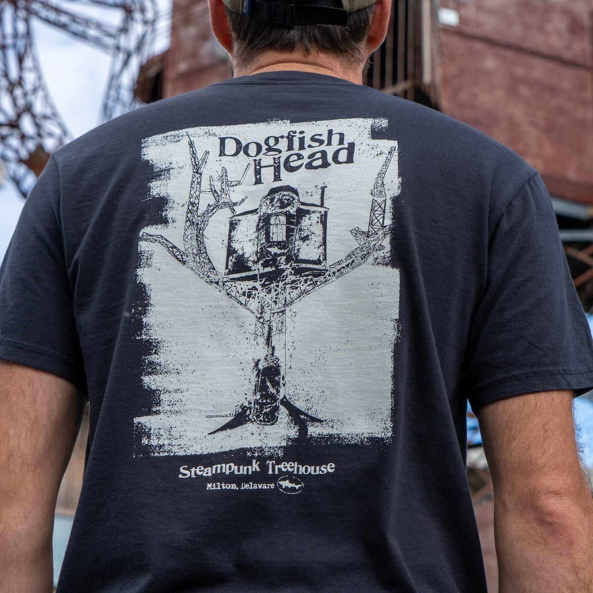Male standing wearing black short sleeve tee shirt that says 'dogfish head'