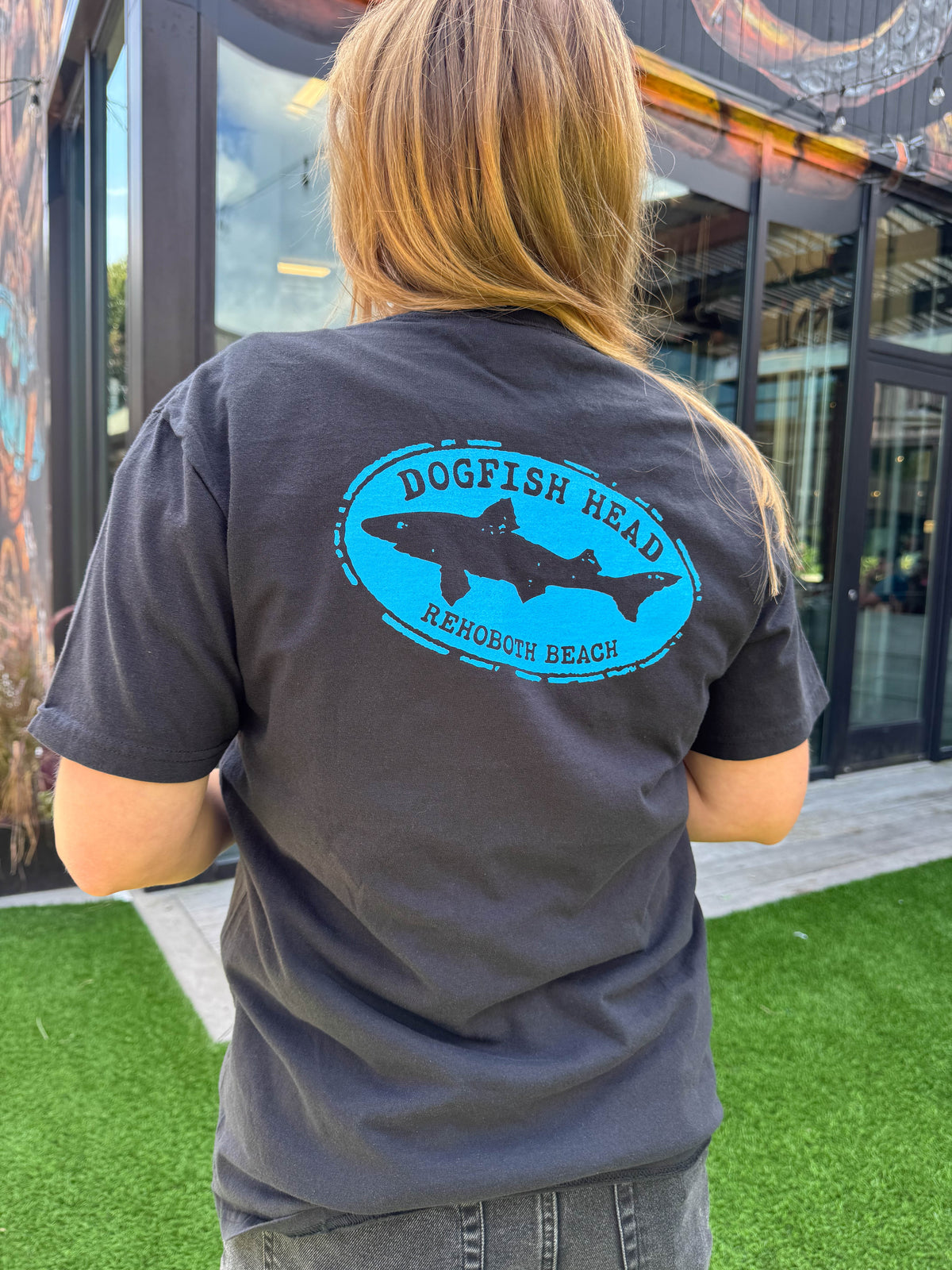 Black tee shirt with blue artwork of an the Dogfish Head logo and says 'rehoboth beach.'
