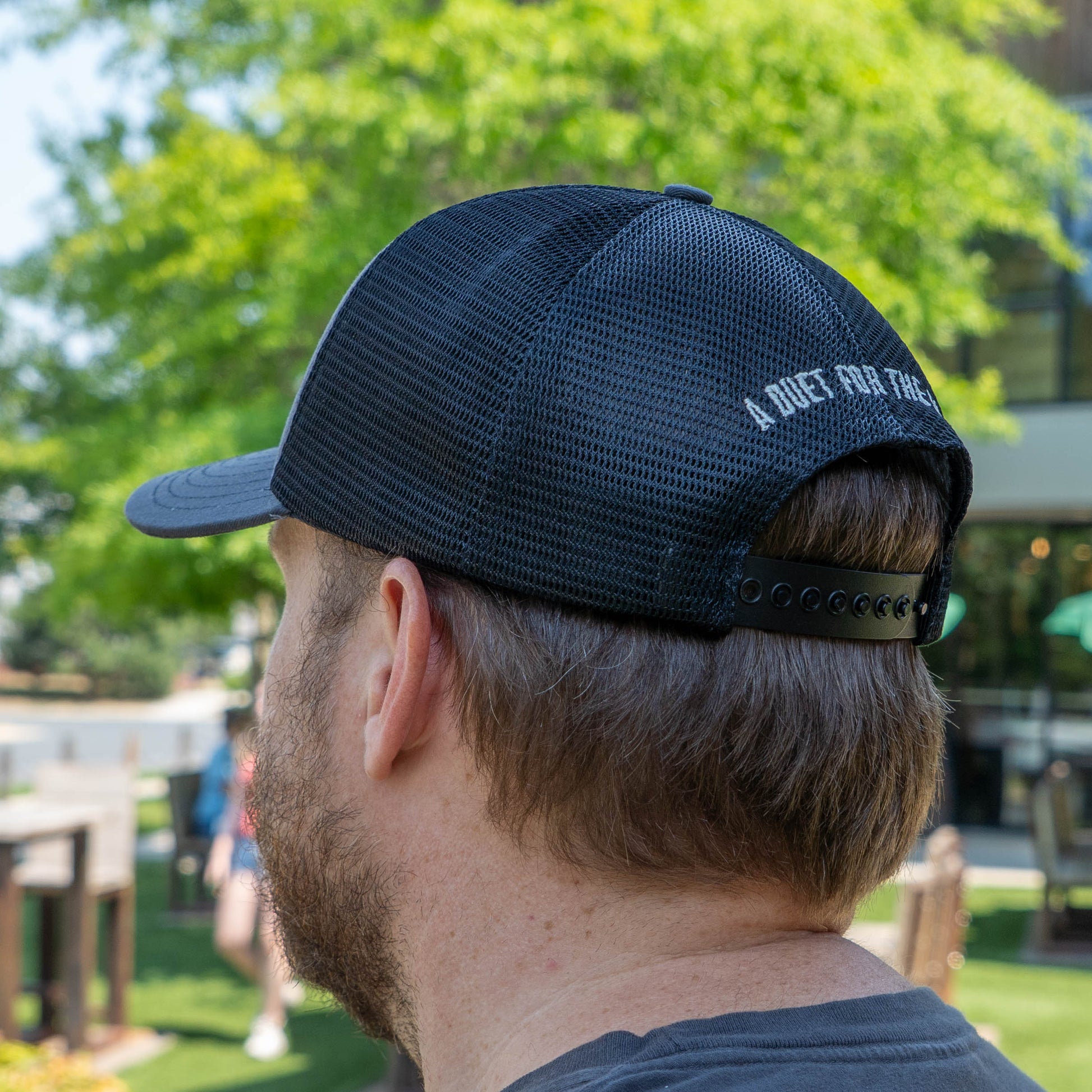 Person wearing a black cap with text outdoors