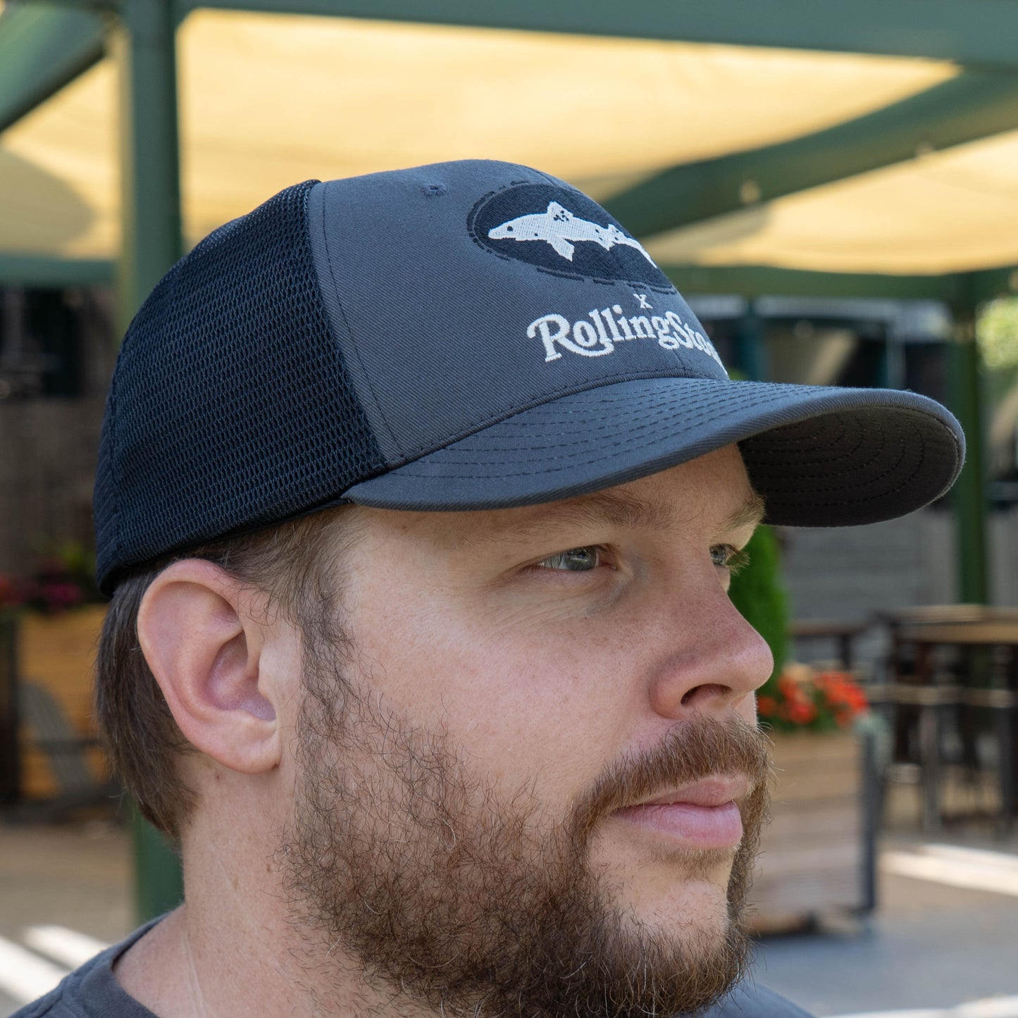 Man wearing a navy blue cap with Dogfish Head x 'RollingStone' logo 