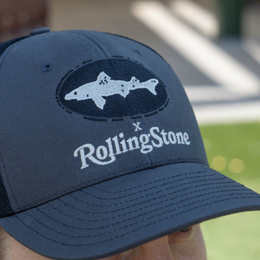 Blue cap with shark logo and 'Rolling Stone' text on a blurred background