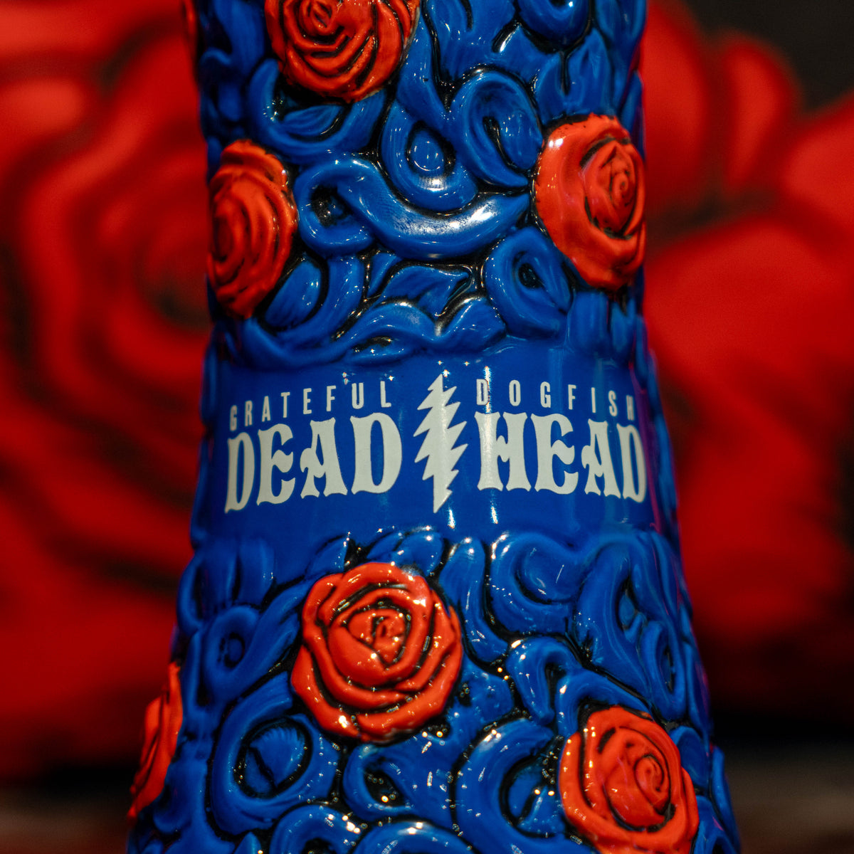 Blue ceramic Dogfish Head x Grateful Dead TIKI FARM ceramic mug decorated with red roses and a lightning bolt, featuring the text Grateful Dead Dogfish Head.
