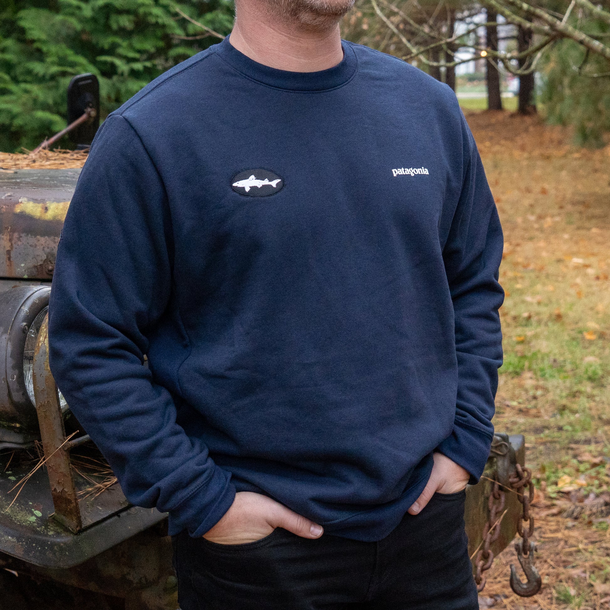 Person wearing a navy Patagonia sweatshirt with a Dogfish Head logo, standing outdoors.