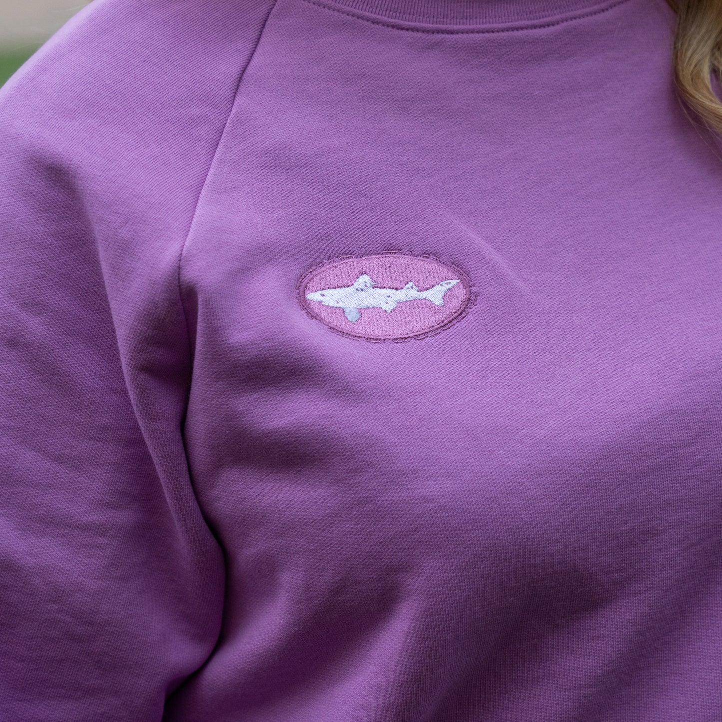 Purple sweatshirt with a shark logo on the chest