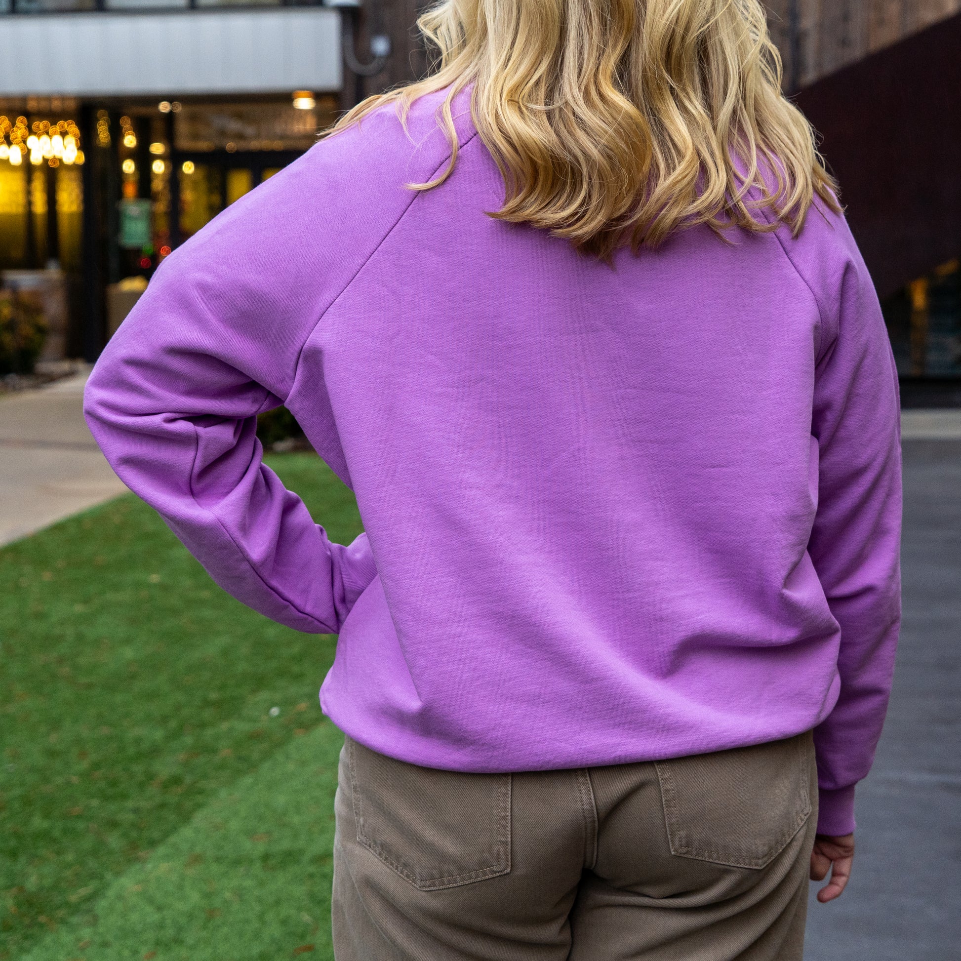 Person wearing a purple sweatshirt with a blurred background