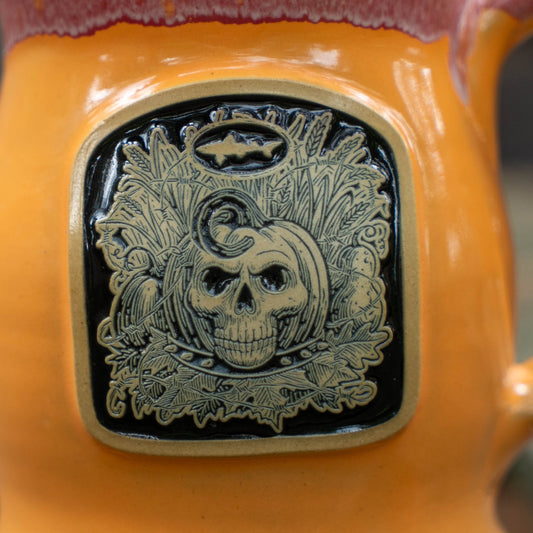 close up of mug artwork of a skeleton face and orange mug.