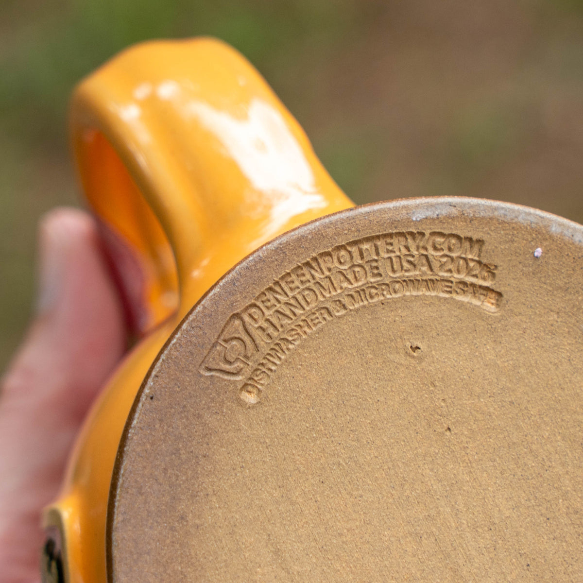 close up image of the manufacturer of the mug 'deneen pottery.com'