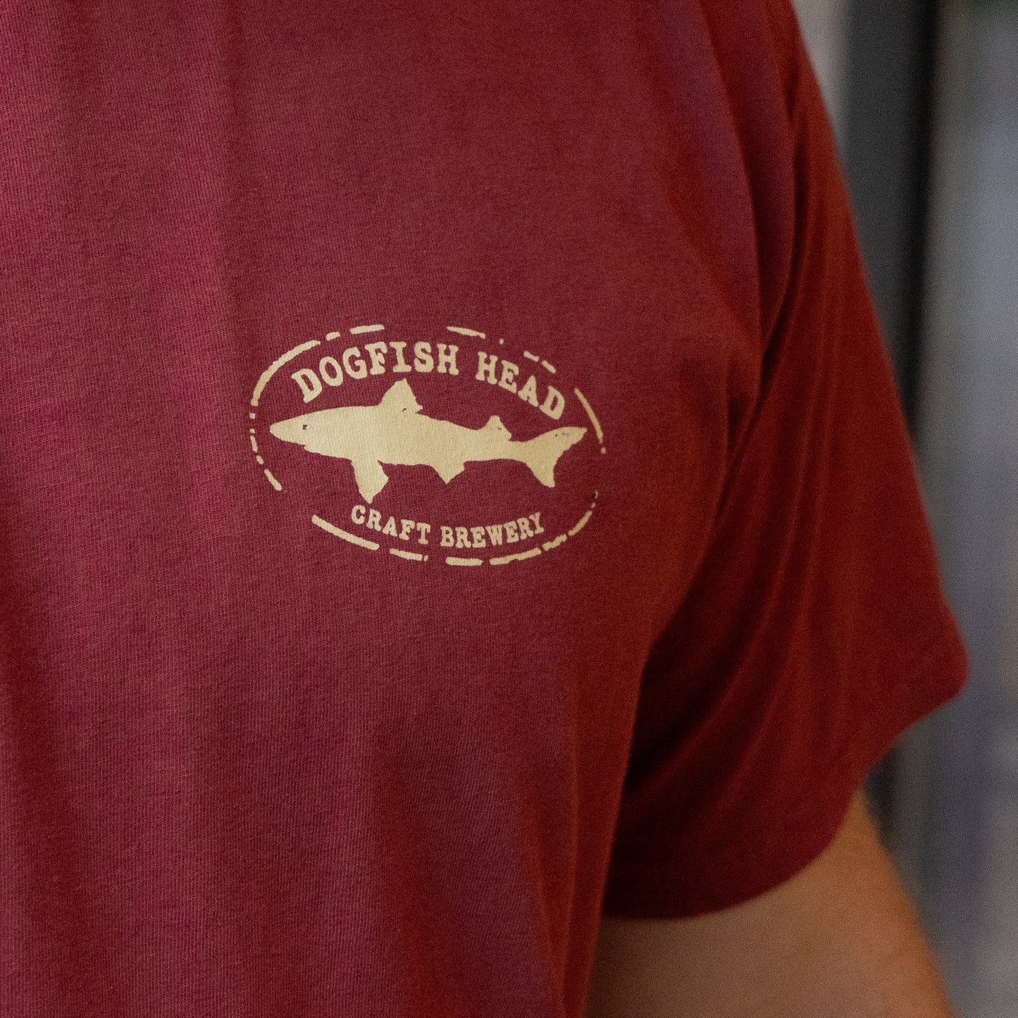Red t-shirt with a shark logo and 'Dogfish Head Craft Brewery' text on a blurred background