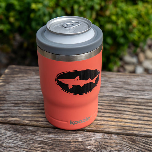 Salmon 12oz Can Insulator in coral, featuring a black shark graphic and holding a beverage can.