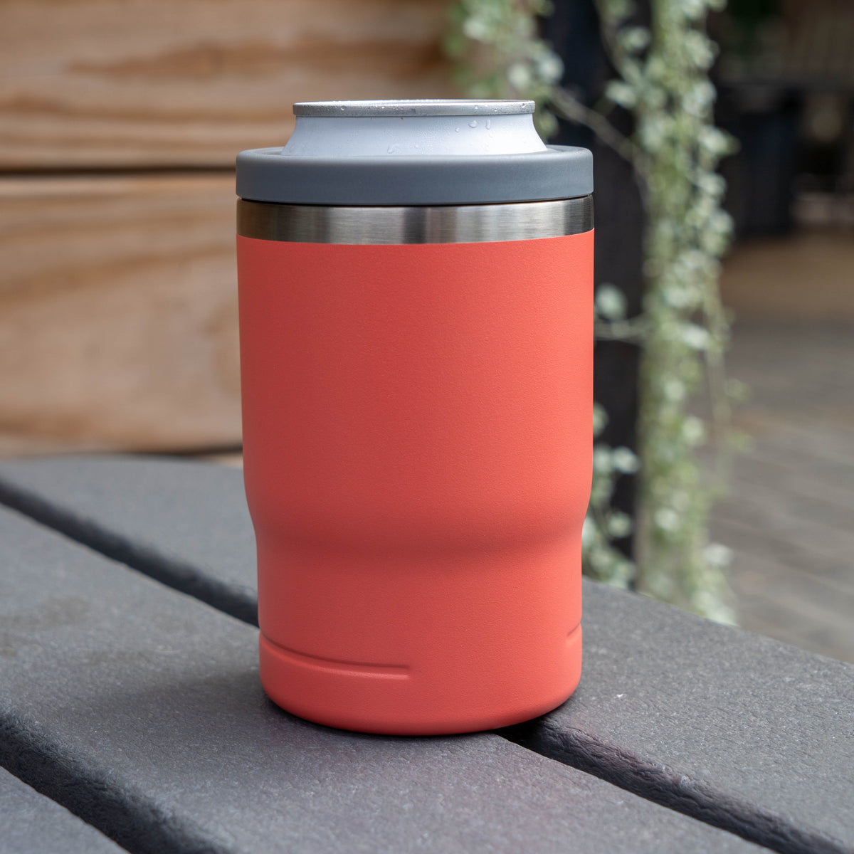 Salmon 12oz Can Insulator in salmon on a gray slatted table.
