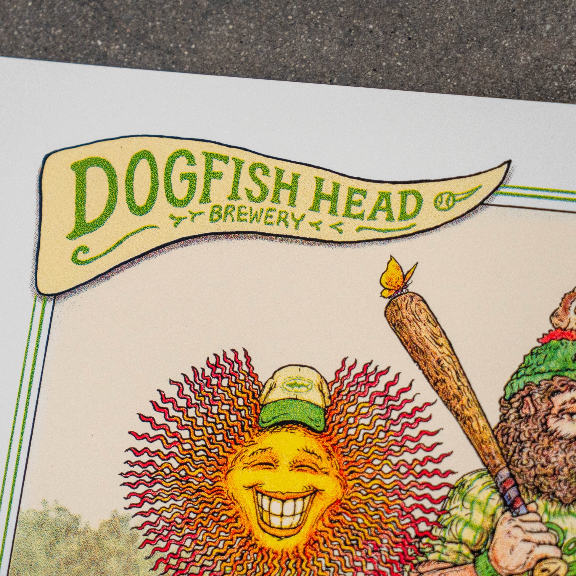 A close-up of the League Champions Limited-Edition Print by Marq Spusta, featuring a smiling sun with a cap and a bearded figure holding a large wooden stick. This collectible artwork, designed in Marq Spusta’s signature style, displays the brewery logo in green and yellow text at the top.