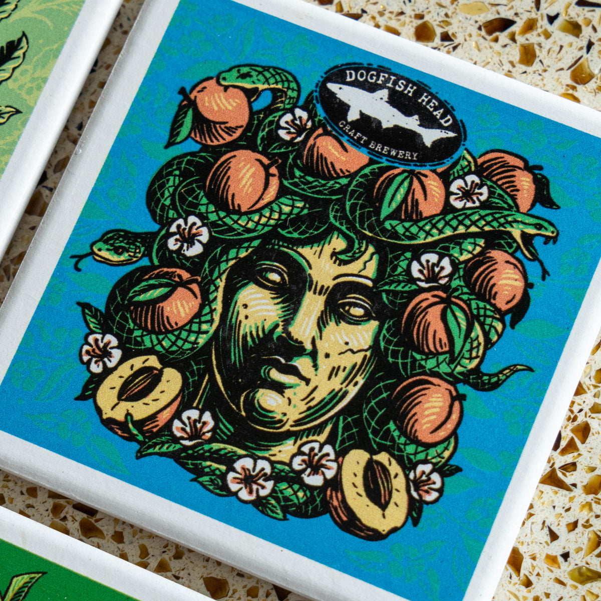 Season-Ale Artist Series Coaster featuring a stylized illustration of Medusa with snakes, peaches, and flowers in her hair, topped with a brewery logo.