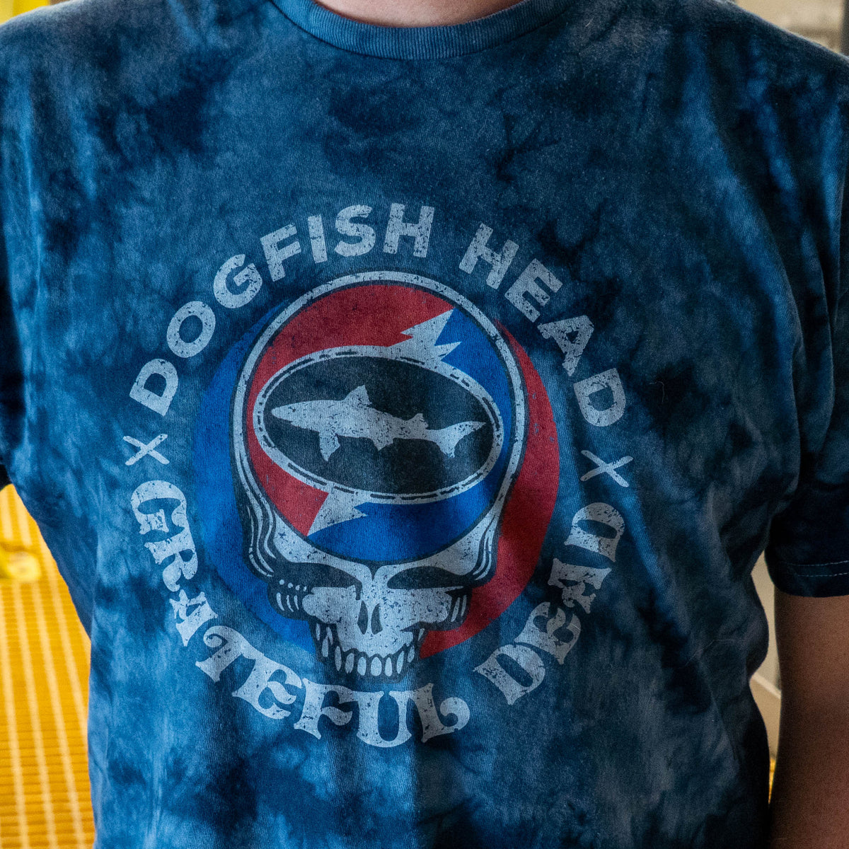 A navy Dogfish Head x Grateful Dead Navy Tie Dye Short Sleeve Tee Shirt featuring a shark silhouette inside a circular logo.