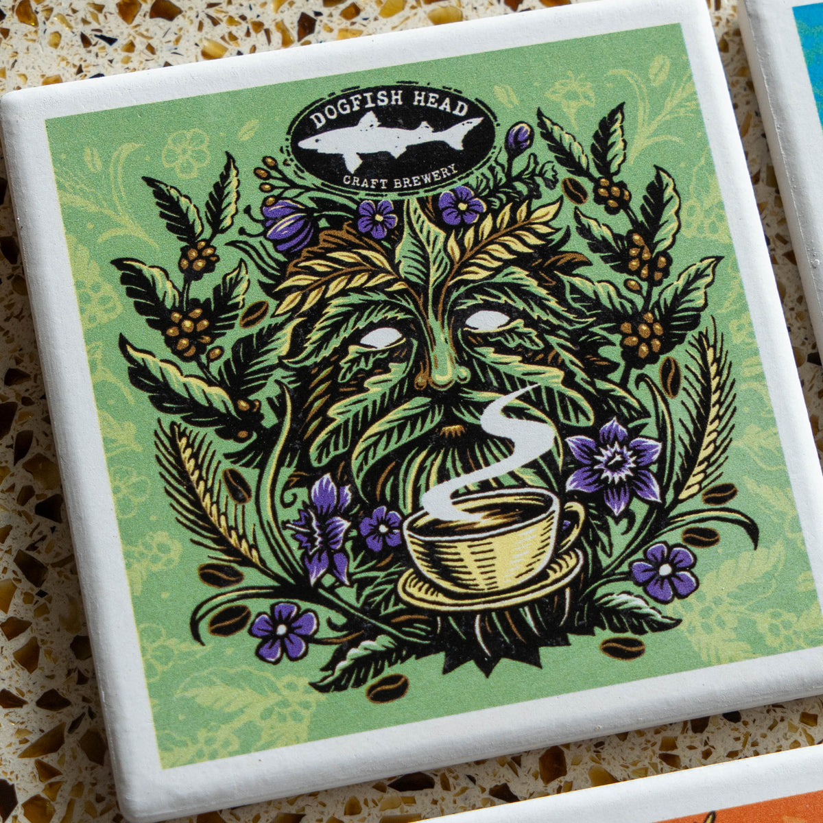 Square Season-Ale Artist Series Coaster Set featuring a stylized illustration of a green, leafy face holding a steaming cup of coffee, surrounded by flowers and wheat, with a fish logo at the top.