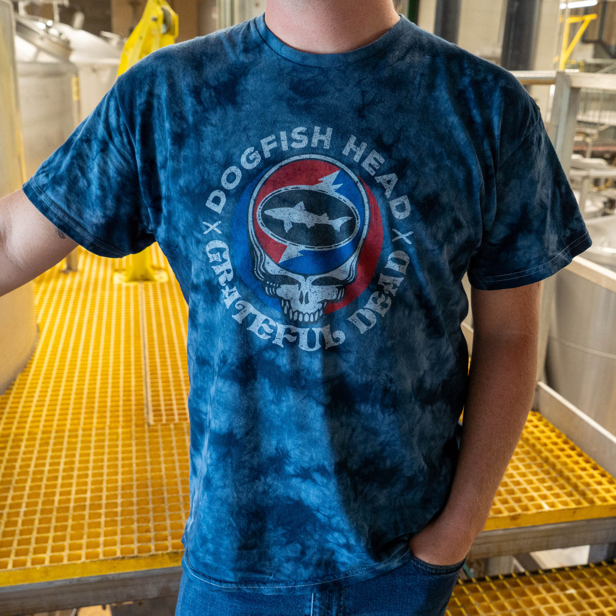 Short sleeve navy tie dye tee shirt on person with hand in their pocket. Featuring Grateful dead skull logo in the center.